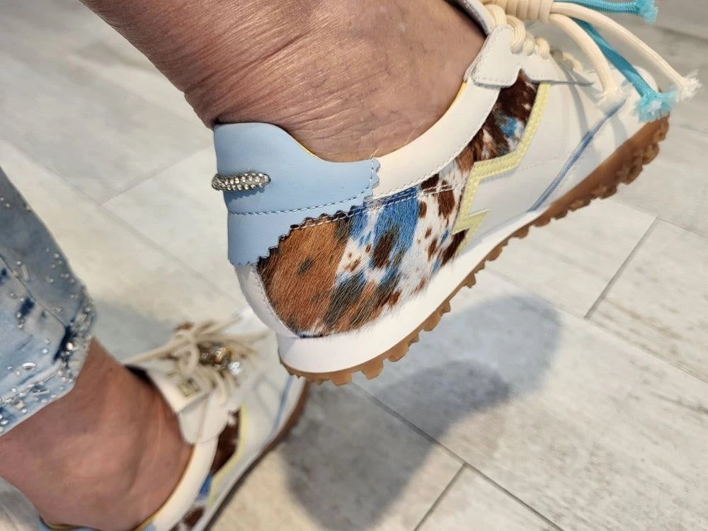 Baskets GIO modèle Cielo en cuir blanc et veau, sublimées par des détails en bleu ciel. Empiècements contrastants et accessoires en cuir véritable, lacets plats assortis pour une finition épurée. Semelle en caoutchouc ultra légère de couleur beige avec talon surélevé de 3,5 cm pour plus de confort. Doublure intérieure en cuir véritable et semelle intérieure amovible pour un ajustement personnalisé. Un modèle intemporel alliant élégance et praticité au quotidien.