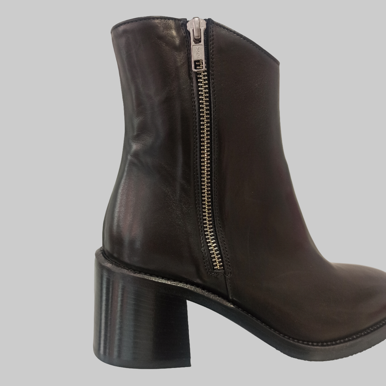 Bottines en cuir noir véritable alliant élégance et praticité. Dotées d'un talon de 5,5 cm qui affine la silhouette sans compromettre le confort, ces bottines se distinguent par leurs deux fermetures éclair latérales qui facilitent grandement l'enfilage. Le bout rond épouse délicatement la forme du pied pour une journée sans fatigue. Un incontournable pour les femmes en quête d'une chaussure polyvalente, à la fois chic et fonctionnelle, adaptée à tous les styles et occasions.