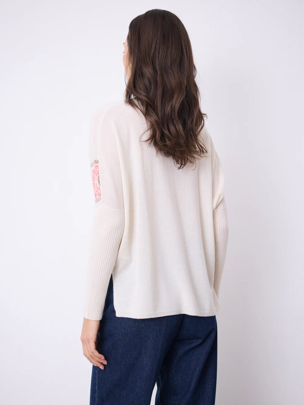 Pull poncho pour femme en cachemire 100% pur, 2 fils jauge 12, offrant une douceur incomparable et une chaleur enveloppante. Coupe généreuse et élégante avec col V et manches longues, parfaite pour un style décontracté chic. Détails distinctifs : imprimé provençale subtil qui apporte une touche de caractère, fentes latérales pour plus de liberté de mouvement, et finitions bords-côtes soignées pour une tenue impeccable. Idéal pour les journées fraîches, ce pull combine confort et sophistication. La teinte éc