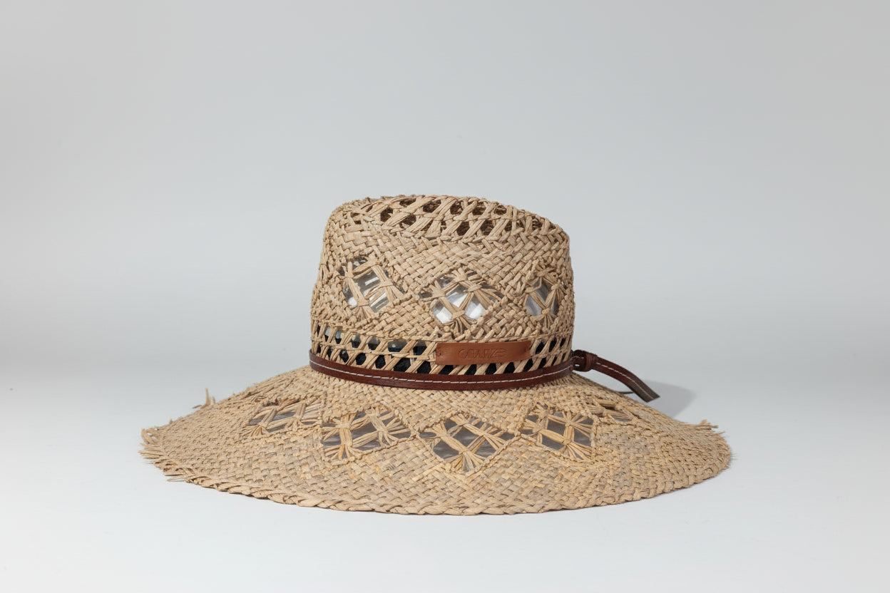 Chapeau de paille tressé à la main en fibres naturelles par la maison familiale Catarzi à Florence en Italie. Cet accessoire intemporel allie savoir-faire artisanal et élégance naturelle. Parfait pour les beaux jours, il offre protection et style avec l'authenticité d'une création italienne traditionnelle. 