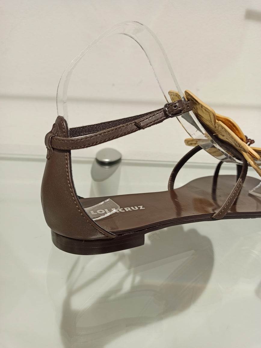 Fleur en cuir sur le dessus du cou de pied, elle transforme votre allure
par son élégance. Les pistils bronzes ornent le coeur de cette belle
plante.