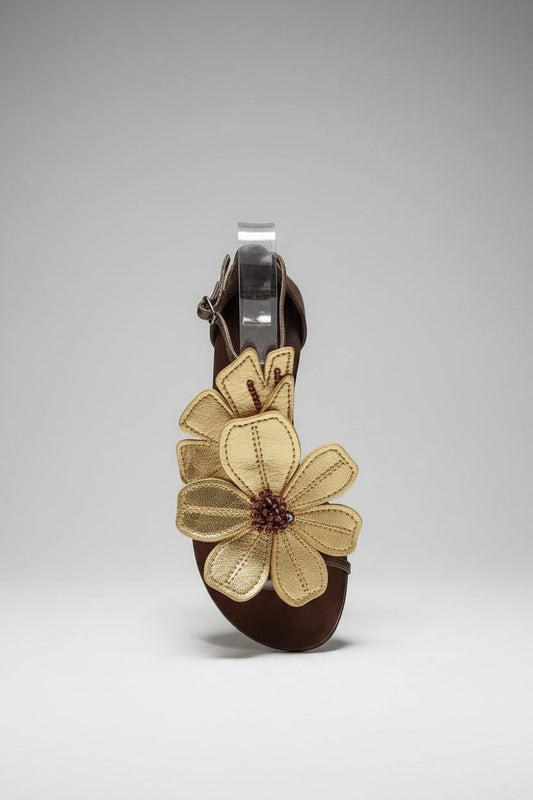 Fleur en cuir sur le dessus du cou de pied, elle transforme votre allure
par son élégance. Les pistils bronzes ornent le coeur de cette belle
plante.