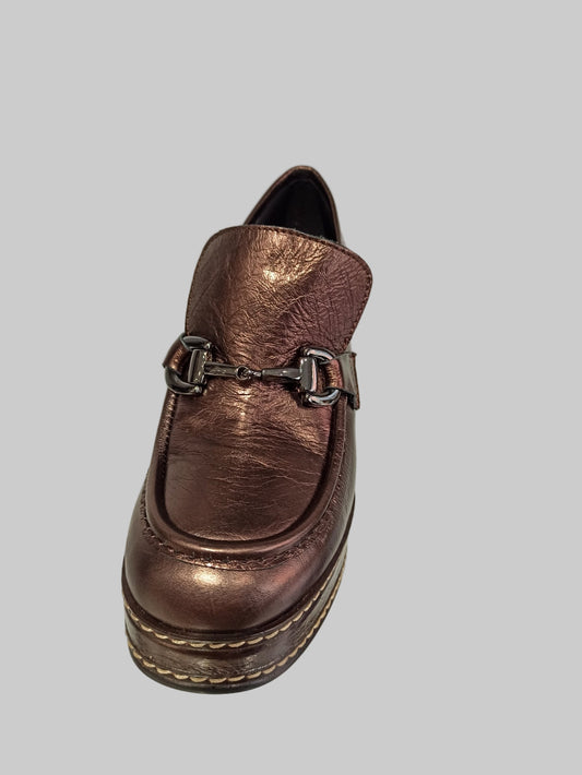 Découvrez l'allure intemporelle de ces mocassins Pons Quintana, où le cuir bronze métallisé rencontre une finition glitter captivante. Le talon plateforme combine élégance et praticité, offrant un soutien optimal tout en sublimant votre silhouette. La boucle discrète apporte cette touche de raffinement qui transforme chaque pas en déclaration de style. Idéals pour les femmes qui refusent de compromis entre confort et sophistication, ces mocassins deviennent vos alliés incontournables pour un look à la fois