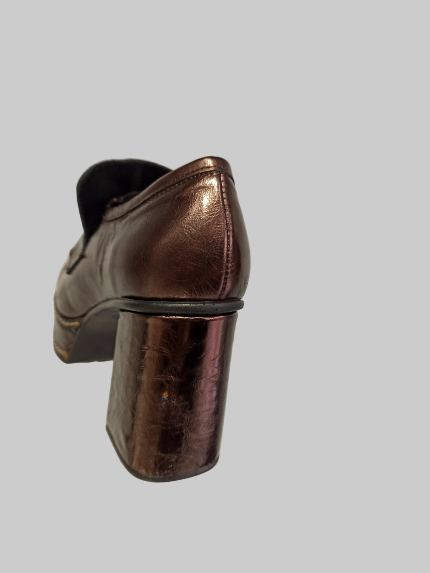 Découvrez l'allure intemporelle de ces mocassins Pons Quintana, où le cuir bronze métallisé rencontre une finition glitter captivante. Le talon plateforme combine élégance et praticité, offrant un soutien optimal tout en sublimant votre silhouette. La boucle discrète apporte cette touche de raffinement qui transforme chaque pas en déclaration de style. Idéals pour les femmes qui refusent de compromis entre confort et sophistication, ces mocassins deviennent vos alliés incontournables pour un look à la fois