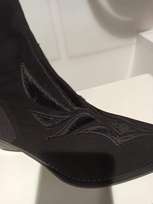 Découvrez cette santiag Sartore d'exception, où le daim noir se pare d'un délicat travail de broderie en pony noir ton sur ton. Chaque détail révèle le savoir-faire artisanal de la maison, transformant cette botte en véritable merveille. Le contraste subtil entre les textures crée une élégance intemporelle, parfaite pour affirmer votre style avec raffinement. Une pièce d'exception qui mérite une place de choix dans votre garde-robe.