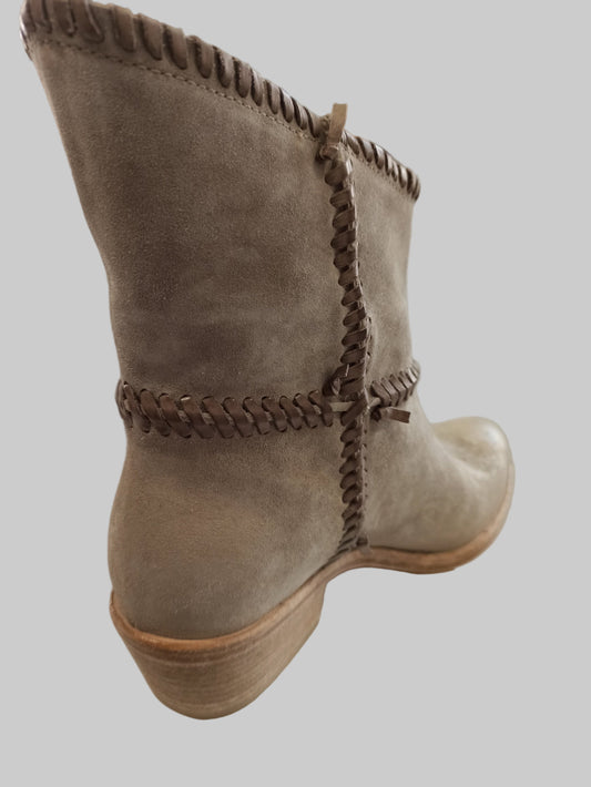 Découvrez nos boots en cuir nubuck taupe, inspirées par l'esthétique amérindienne intemporelle. Dotées d'une tige inversée et d'un surlacage distinctif, ces chaussures allient style authentique et confort exceptionnel. Leur design spacieux permet d'enfiler facilement un jean à l'intérieur de la tige, créant une silhouette élégante et décontractée. Parfaites pour un look loungewear chic, elles transforment vos tenues quotidiennes en créations sophistiquées. Investissez dans une paire qui conjugue caractère,