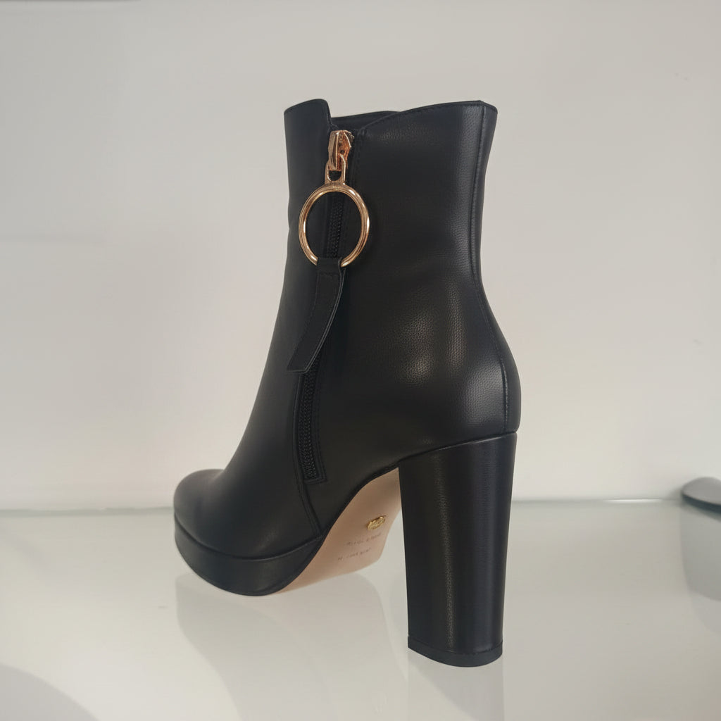 Avec leur fermeture éclair latérale pratique, ces chaussures sont faciles à enfiler, ce qui vous permet de les porter rapidement lors de vos sorties. Le design contemporain se démarque grâce à un gros anneau noir en bronze, ajoutant une touche d'originalité à votre tenue.