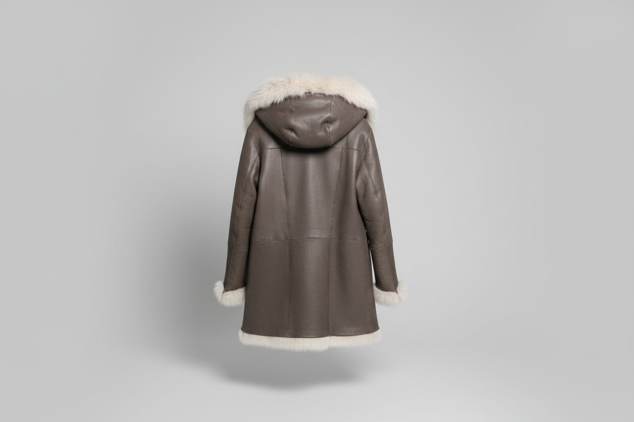 Découvrez l'élégance intemporelle de ce manteau en mouton retourné aux poils longs, véritable pièce maîtresse de votre garde-robe hivernale. Confectionné en peau glacée chocolat, il conjugue luxe et confort avec son design réversible qui offre deux styles en un. La capuche généreuse et les poils longs créent une silhouette enveloppante et sophistiquée, parfaite pour les journées froides. Polyvalent et incontournable, ce manteau transforme chaque sortie en moment de prestige.
