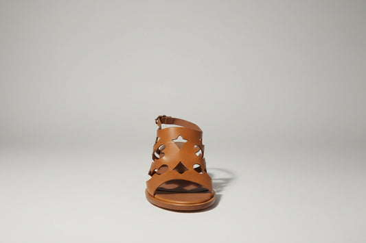 Découvrez les sandales Sartore, une fusion audacieuse entre élégance western et raffinement contemporain. Dotées d'un talon de 5 cm qui allonge la silhouette sans compromettre le confort, ces sandales allient style santiag intemporel et détails sophistiqués. Le cuir camel premium, travaillé par des découpes laser précises, crée un motif géométrique captivant qui capture la lumière à chaque pas. La semelle cousue main garantit une durabilité exceptionnelle et un maintien optimal, tandis que la construction a