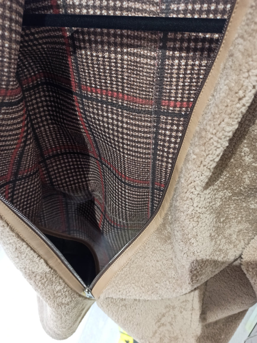Découvrez ce manteau intemporel alliant élégance et confort. Doté d'une capuche généreuse, il combine un extérieur en cuir noisette avec un intérieur douillet en mouton et tartan, créant une pièce polyvalente parfaite pour les transitions saisonnières. Le contraste entre la finition cuir premium et la chaleur de la doublure en mouton offre une protection optimale contre les éléments, tandis que le tartan intérieur ajoute une touche de caractère intemporel. Un investissement durable pour votre garde-robe.
