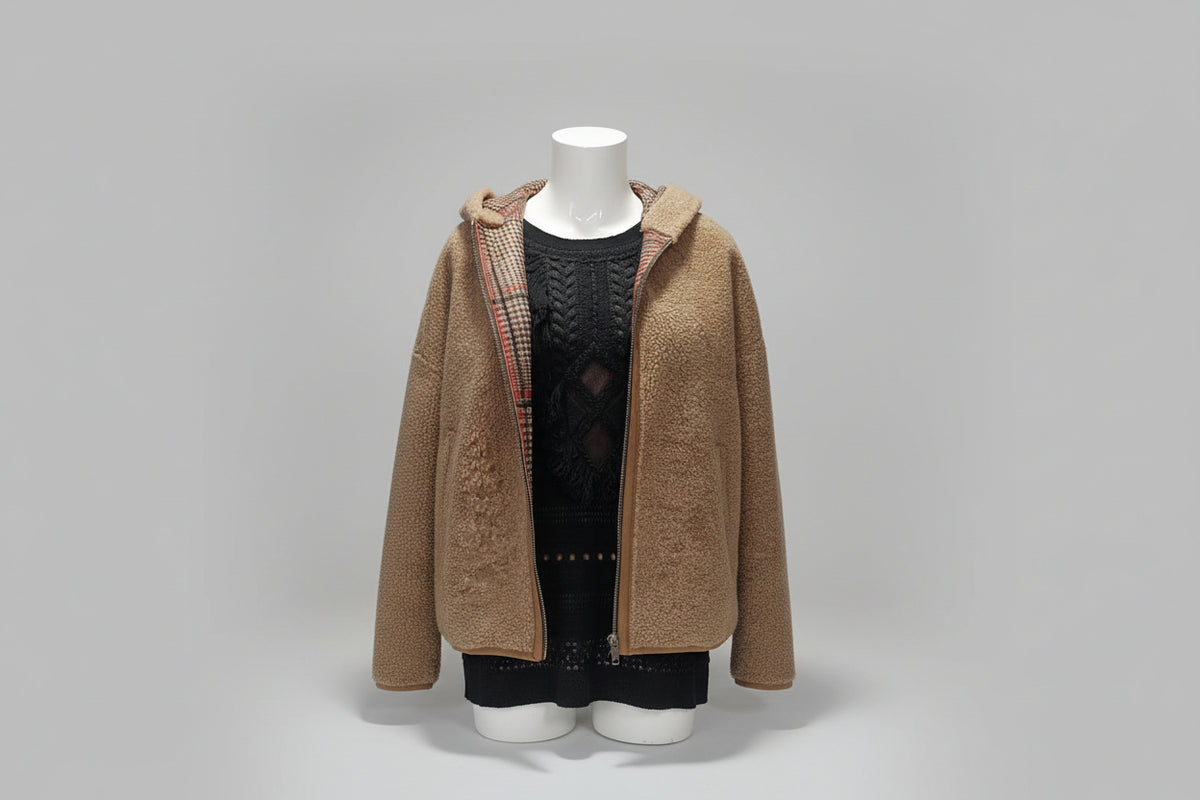 Découvrez ce manteau intemporel alliant élégance et confort. Doté d'une capuche généreuse, il combine un extérieur en cuir noisette avec un intérieur douillet en mouton et tartan, créant une pièce polyvalente parfaite pour les transitions saisonnières. Le contraste entre la finition cuir premium et la chaleur de la doublure en mouton offre une protection optimale contre les éléments, tandis que le tartan intérieur ajoute une touche de caractère intemporel. Un investissement durable pour votre garde-robe.