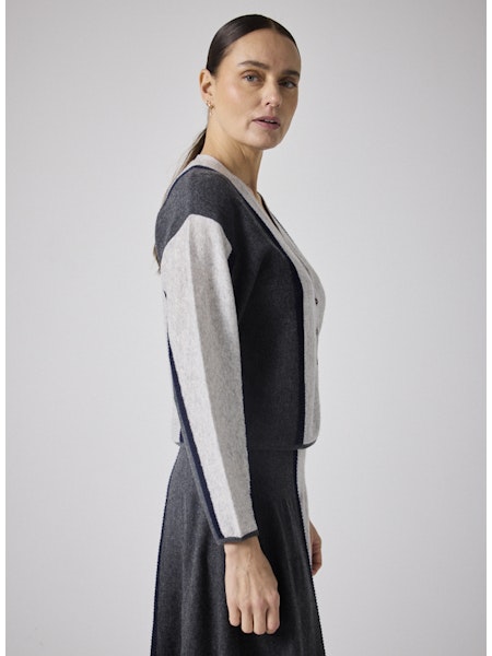 Découvrez le gilet Clarence de Notshy, une pièce élégante confectionnée à 90 % en laine et 10 % en cachemire pour une douceur et un confort incomparables. Son col en V classique s’accompagne de cinq boutons recouverts de laine, apportant une touche sophistiquée. Les deux liserés droits au crochet marine sur le devant et sur les manches ajoutent un détail raffiné, tandis que la finition côtelée garantit une tenue impeccable. Idéal pour sublimer vos tenues avec style tout en vous tenant au chaud.