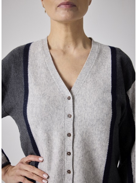 Découvrez le gilet Clarence de Notshy, une pièce élégante confectionnée à 90 % en laine et 10 % en cachemire pour une douceur et un confort incomparables. Son col en V classique s’accompagne de cinq boutons recouverts de laine, apportant une touche sophistiquée. Les deux liserés droits au crochet marine sur le devant et sur les manches ajoutent un détail raffiné, tandis que la finition côtelée garantit une tenue impeccable. Idéal pour sublimer vos tenues avec style tout en vous tenant au chaud.