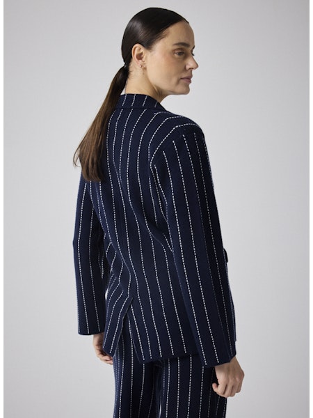 Cette veste blazer Owen marine allie élégance et confort grâce à sa coupe tailleur soulignée par une surpiqûre écrue raffinée. Conçue avec un mélange haut de gamme de 90 % laine et 10 % cachemire, elle vous assure chaleur et douceur tout en renforçant votre allure élégante. Idéale pour sublimer toutes vos tenues, cette pièce essentielle offre une silhouette structurée avec ses deux boutons et revers classiques. Adoptez un style chic et contemporain avec cette veste polyvalente qui vous accompagnera au quoti