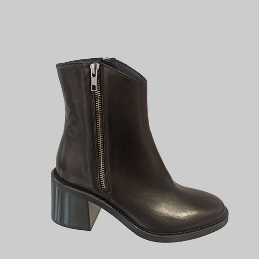 Bottines en cuir noir véritable alliant élégance et praticité. Dotées d'un talon de 5,5 cm qui affine la silhouette sans compromettre le confort, ces bottines se distinguent par leurs deux fermetures éclair latérales qui facilitent grandement l'enfilage. Le bout rond épouse délicatement la forme du pied pour une journée sans fatigue. Un incontournable pour les femmes en quête d'une chaussure polyvalente, à la fois chic et fonctionnelle, adaptée à tous les styles et occasions.