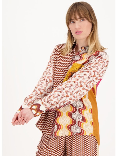 Découvrez le chemisier Isabel imprimé, une pièce incontournable de votre garde-robe. Ce chemisier à manches longues se démarque grâce à son design unique avec un mélange de blocs géométriques dans des tons chaleureux de tons, oranges et bruns. La chemise présente également un écusson floral orange à l'avant, ajoutant une touche de fraîcheur et d'originalité.