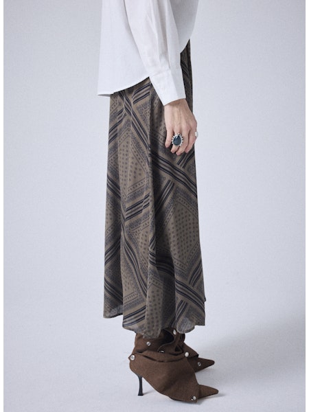 Découvrez la jupe midi Notshy Cody, alliant élégance et confort grâce à sa taille élastiquée et sa coupe droite. Confectionnée dans un mélange doux de 64 % viscose et 36 % modal, elle offre un effet satiné subtil. Son coloris thym avec un imprimé bandana noir apporte une touche originale et raffinée à votre tenue. Parfaite pour sublimer votre silhouette au quotidien ou lors de vos occasions spéciales.