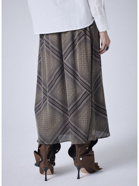 Découvrez la jupe midi Notshy Cody, alliant élégance et confort grâce à sa taille élastiquée et sa coupe droite. Confectionnée dans un mélange doux de 64 % viscose et 36 % modal, elle offre un effet satiné subtil. Son coloris thym avec un imprimé bandana noir apporte une touche originale et raffinée à votre tenue. Parfaite pour sublimer votre silhouette au quotidien ou lors de vos occasions spéciales.