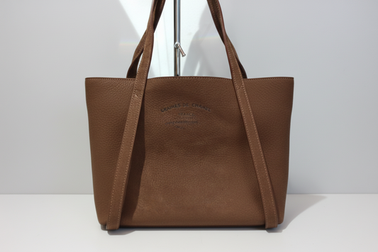 Le Petit Touquet, un incontournable de la maison Charles et Charlus. Confectionné en cuir nubuck marron, ce sac allie élégance et polyvalence. Ses surpiqûres écrue apportent une touche de raffinement discret. Dimensions : 34 x 30 cm. Trois façons de le porter selon vos envies : en grande bandoulière réglable pour plus de liberté, sur l'épaule pour un style classique, ou à la main pour une allure épurée. Toutes les bandoulières sont amovibles, vous offrant une flexibilité maximale au quotidien. Un compagnon 