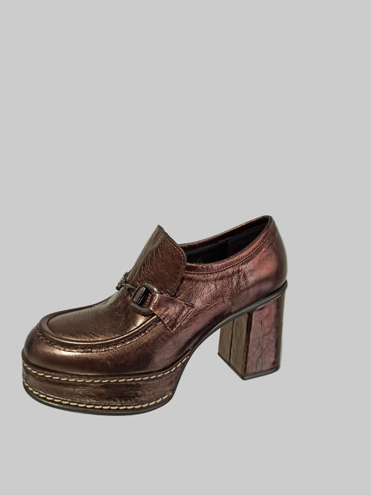 Découvrez l'allure intemporelle de ces mocassins Pons Quintana, où le cuir bronze métallisé rencontre une finition glitter captivante. Le talon plateforme combine élégance et praticité, offrant un soutien optimal tout en sublimant votre silhouette. La boucle discrète apporte cette touche de raffinement qui transforme chaque pas en déclaration de style. Idéals pour les femmes qui refusent de compromis entre confort et sophistication, ces mocassins deviennent vos alliés incontournables pour un look à la fois