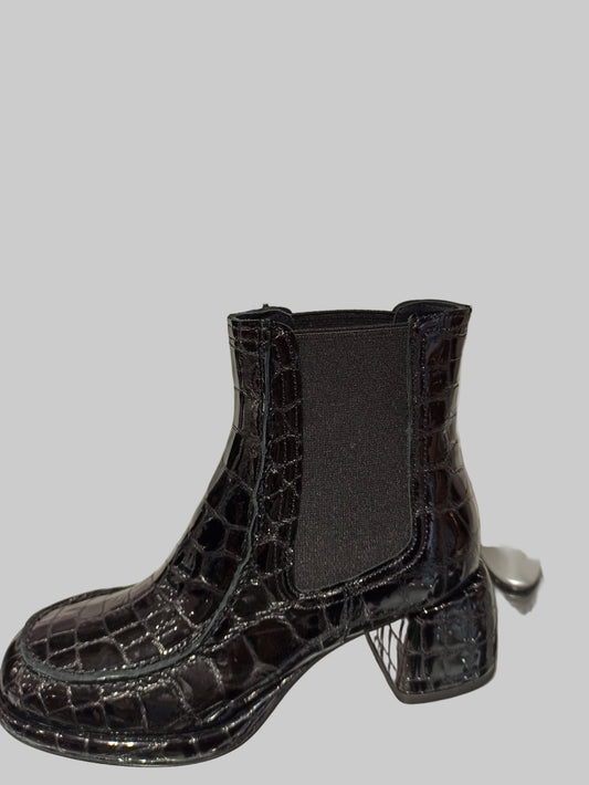 Alliant élégance et caractère, ces Chelsea boots en cuir vernis noir embossé offrent un style unique et contemporain. Leur talon carré de 4 cm assure une démarche confortable et raffinée, tandis que la semelle en cuir garantit durabilité et qualité. Idéales pour sublimer vos looks avec une touche sophistiquée, ces boots sont un incontournable pour celles qui recherchent à la fois style et confort.