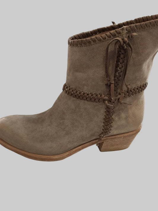 Découvrez nos boots en cuir nubuck taupe, inspirées par l'esthétique amérindienne intemporelle. Dotées d'une tige inversée et d'un surlacage distinctif, ces chaussures allient style authentique et confort exceptionnel. Leur design spacieux permet d'enfiler facilement un jean à l'intérieur de la tige, créant une silhouette élégante et décontractée. Parfaites pour un look loungewear chic, elles transforment vos tenues quotidiennes en créations sophistiquées. Investissez dans une paire qui conjugue caractère,