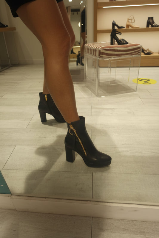 Avec leur fermeture éclair latérale pratique, ces chaussures sont faciles à enfiler, ce qui vous permet de les porter rapidement lors de vos sorties. Le design contemporain se démarque grâce à un gros anneau noir en bronze, ajoutant une touche d'originalité à votre tenue.