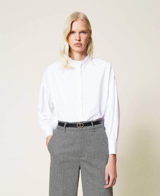 Femme portant un pantalon chevrons en laine mélangée noir avec chemise blanche, look professionnel chic