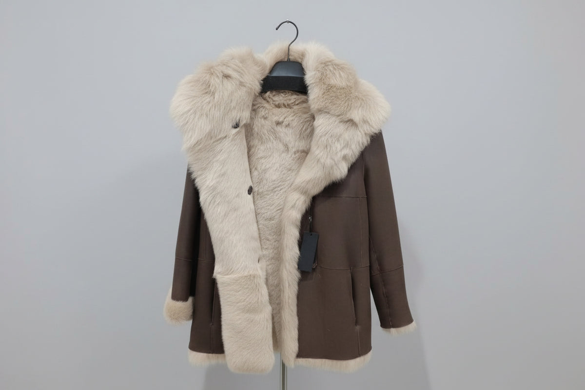 Découvrez l'élégance intemporelle de ce manteau en mouton retourné aux poils longs, véritable pièce maîtresse de votre garde-robe hivernale. Confectionné en peau glacée chocolat, il conjugue luxe et confort avec son design réversible qui offre deux styles en un. La capuche généreuse et les poils longs créent une silhouette enveloppante et sophistiquée, parfaite pour les journées froides. Polyvalent et incontournable, ce manteau transforme chaque sortie en moment de prestige.