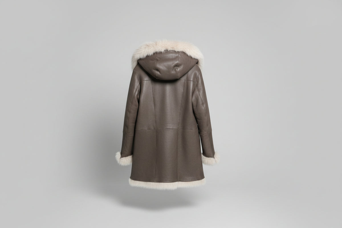 Découvrez l'élégance intemporelle de ce manteau en mouton retourné aux poils longs, véritable pièce maîtresse de votre garde-robe hivernale. Confectionné en peau glacée chocolat, il conjugue luxe et confort avec son design réversible qui offre deux styles en un. La capuche généreuse et les poils longs créent une silhouette enveloppante et sophistiquée, parfaite pour les journées froides. Polyvalent et incontournable, ce manteau transforme chaque sortie en moment de prestige.