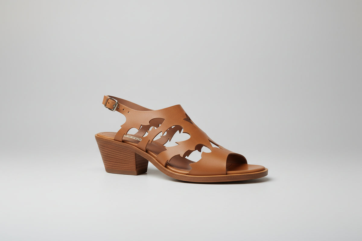 Découvrez les sandales Sartore, une fusion audacieuse entre élégance western et raffinement contemporain. Dotées d'un talon de 5 cm qui allonge la silhouette sans compromettre le confort, ces sandales allient style santiag intemporel et détails sophistiqués. Le cuir camel premium, travaillé par des découpes laser précises, crée un motif géométrique captivant qui capture la lumière à chaque pas. La semelle cousue main garantit une durabilité exceptionnelle et un maintien optimal, tandis que la construction a