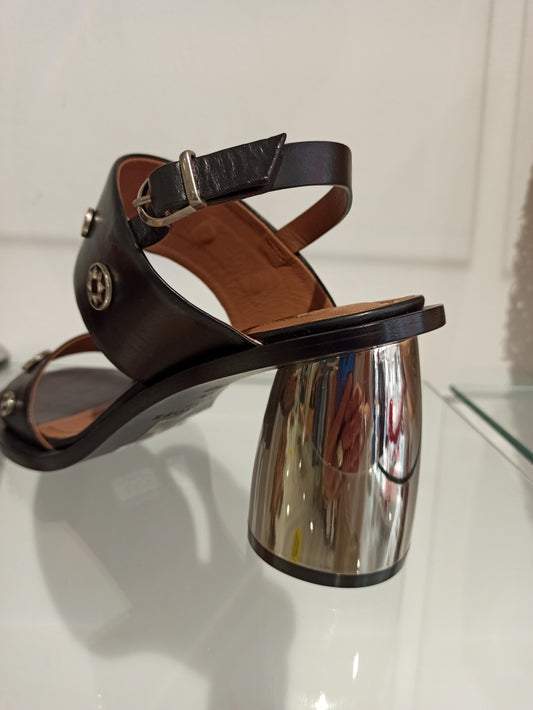 Sandales Sartore : l'alliance parfaite entre héritage western et modernité. Avec son talon de 5 cm qui affine la silhouette, ce modèle signature marie l'intemporalité du style santiag à des détails contemporains raffinés. Le cuir camel premium, travaillé par des découpes laser géométriques, crée un jeu de lumière subtil à chaque mouvement. Cousue main, la semelle assure une durabilité remarquable et un confort sans compromis. Une pièce d'exception pour celles qui recherchent l'élégance authentique—robustess