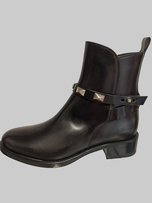 Bottes Sartore en cuir lisse noir, sublimées par une bride ornée de clous argentés. Un design intemporel qui allie élégance classique et détails rock chic. Le cuir premium garantit confort et durabilité, tandis que les clous apportent une touche de caractère affirmé. Parfaites pour structurer vos tenues, du jour au soir. Une paire d'exception qui devient rapidement indispensable.
